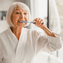 woman brushing teeth in bathroom 